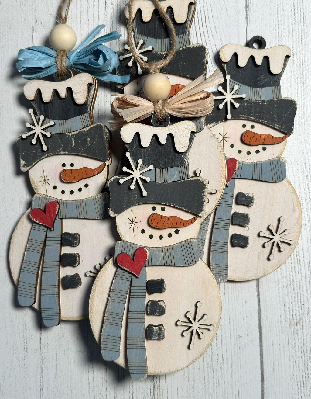 4 rustic snowman ornaments with light blue scarf and raffia bow