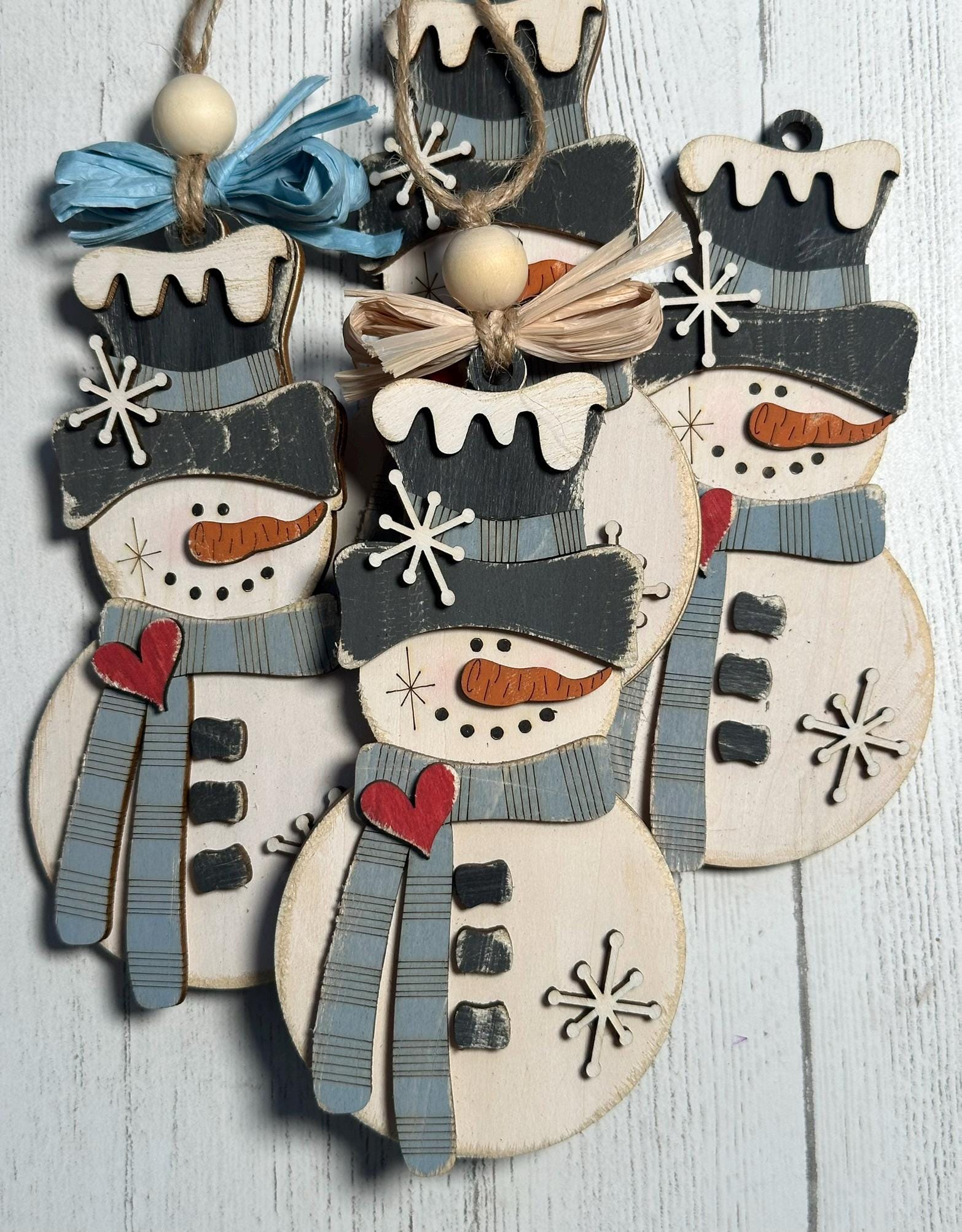 4 rustic snowman ornaments with light blue scarf and raffia bow