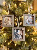a Christmas tree decorated with ornaments, including a wooden frame with a picture of a woman and a star.