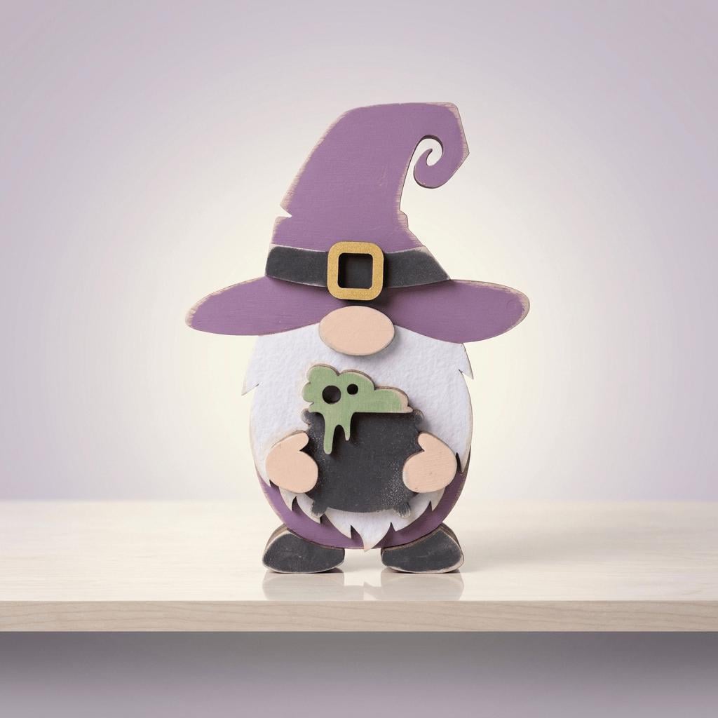 A whimsical wooden gnome figure wearing a purple hat and holding a green object, standing on a white surface against a purple background.